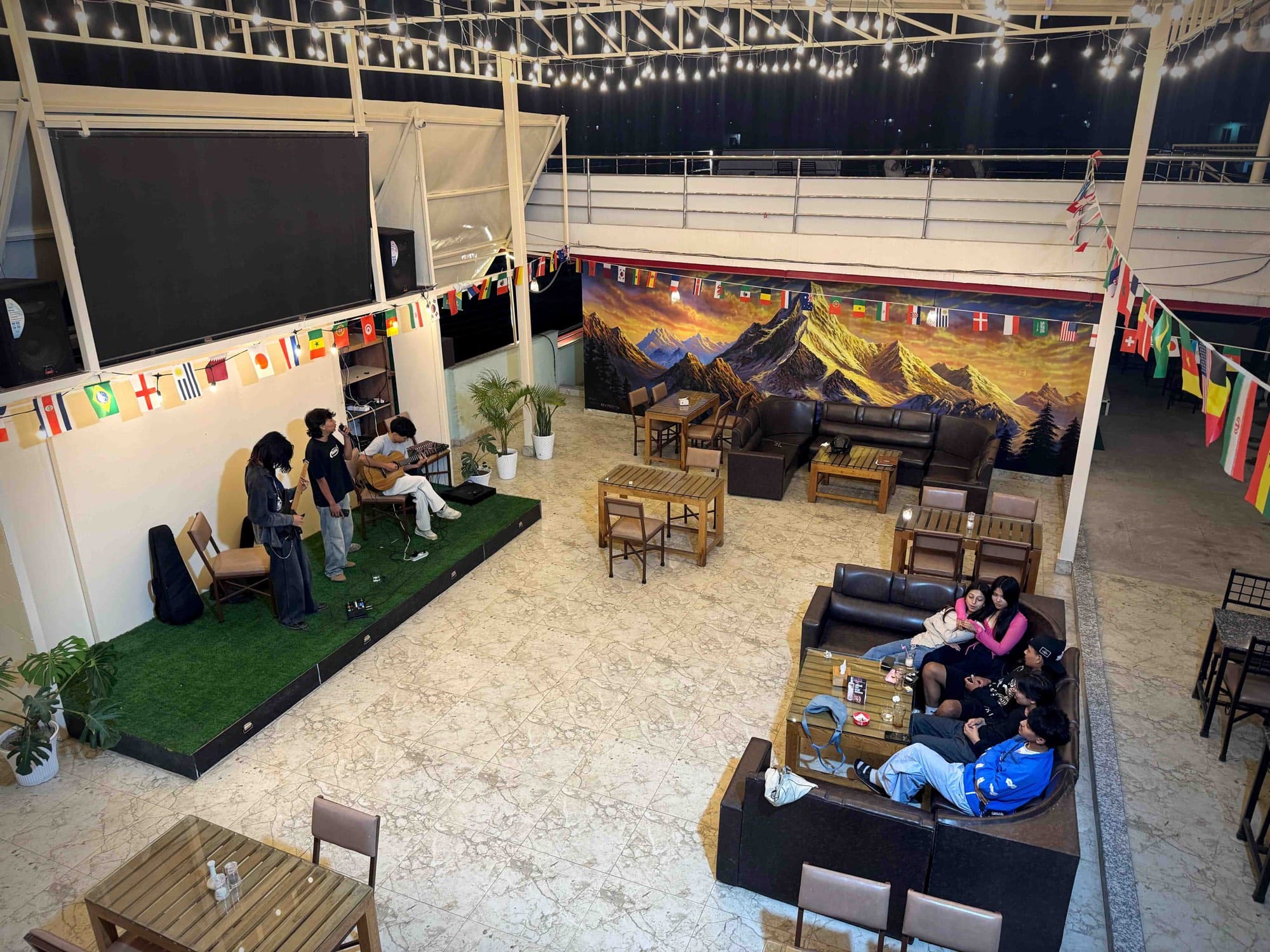 Live folk music on the stage beneath the Everest mural